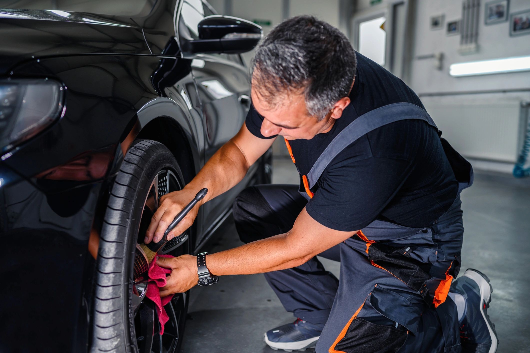 Detailer polishing a car wheel rim