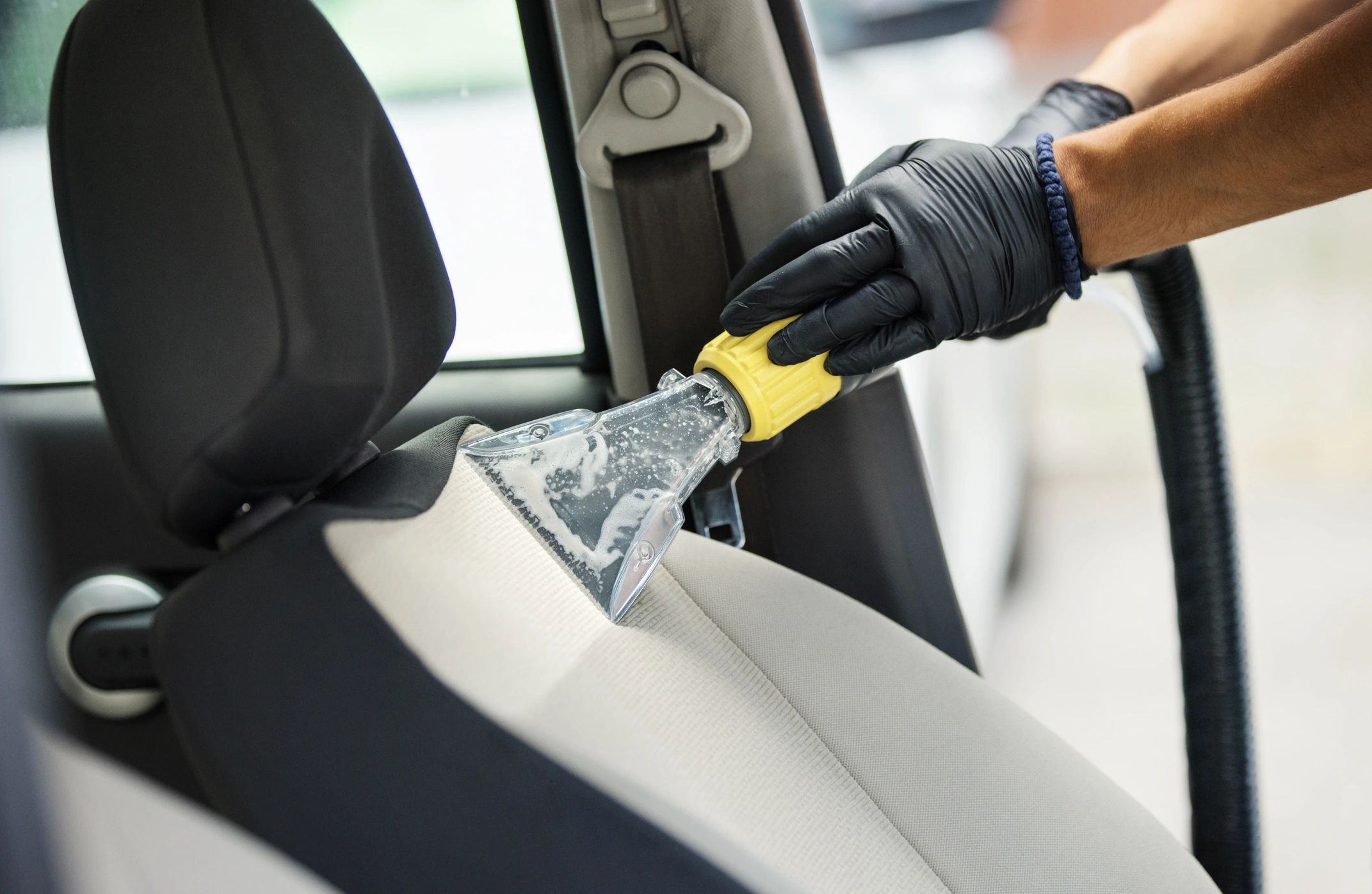Detailer cleaning a vehicle interior
